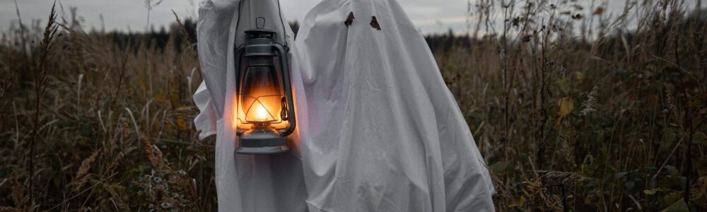 personin ghost costume holding a lantern